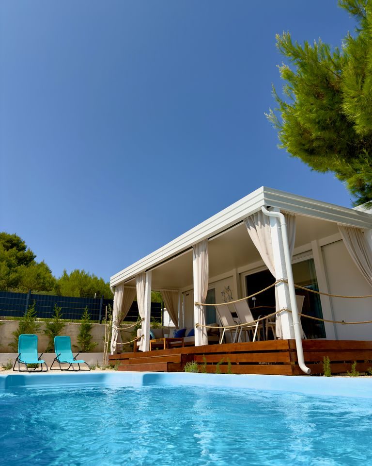 Private fenced heated pool in front of the covered terrace of a Salvia home in Neviđane