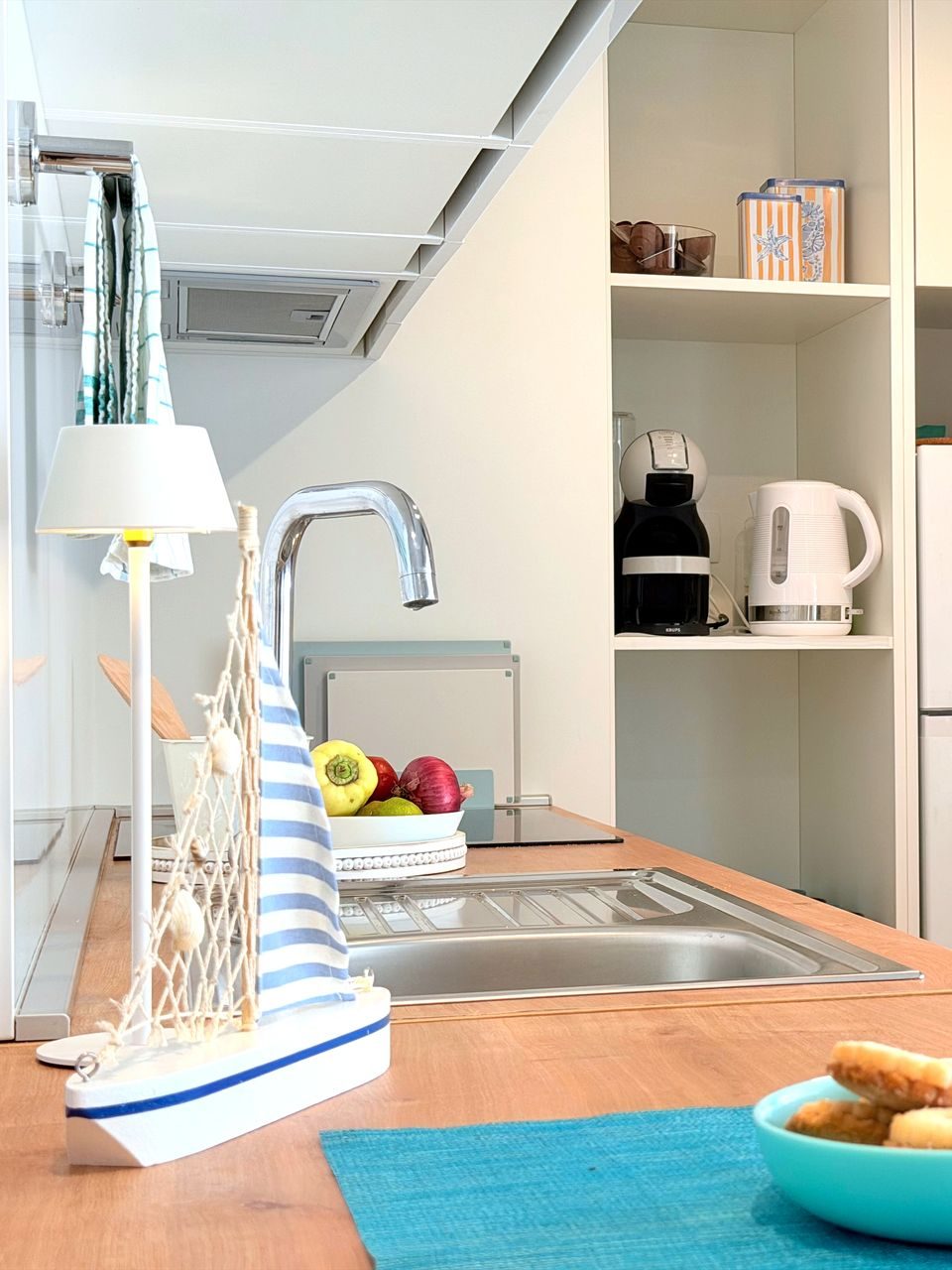Modern kitchen with light wood countertops, white cabinets, stainless steel sink, Gorenje refrigerator, coffee machine, and kettle at Salvia Beachside Homes